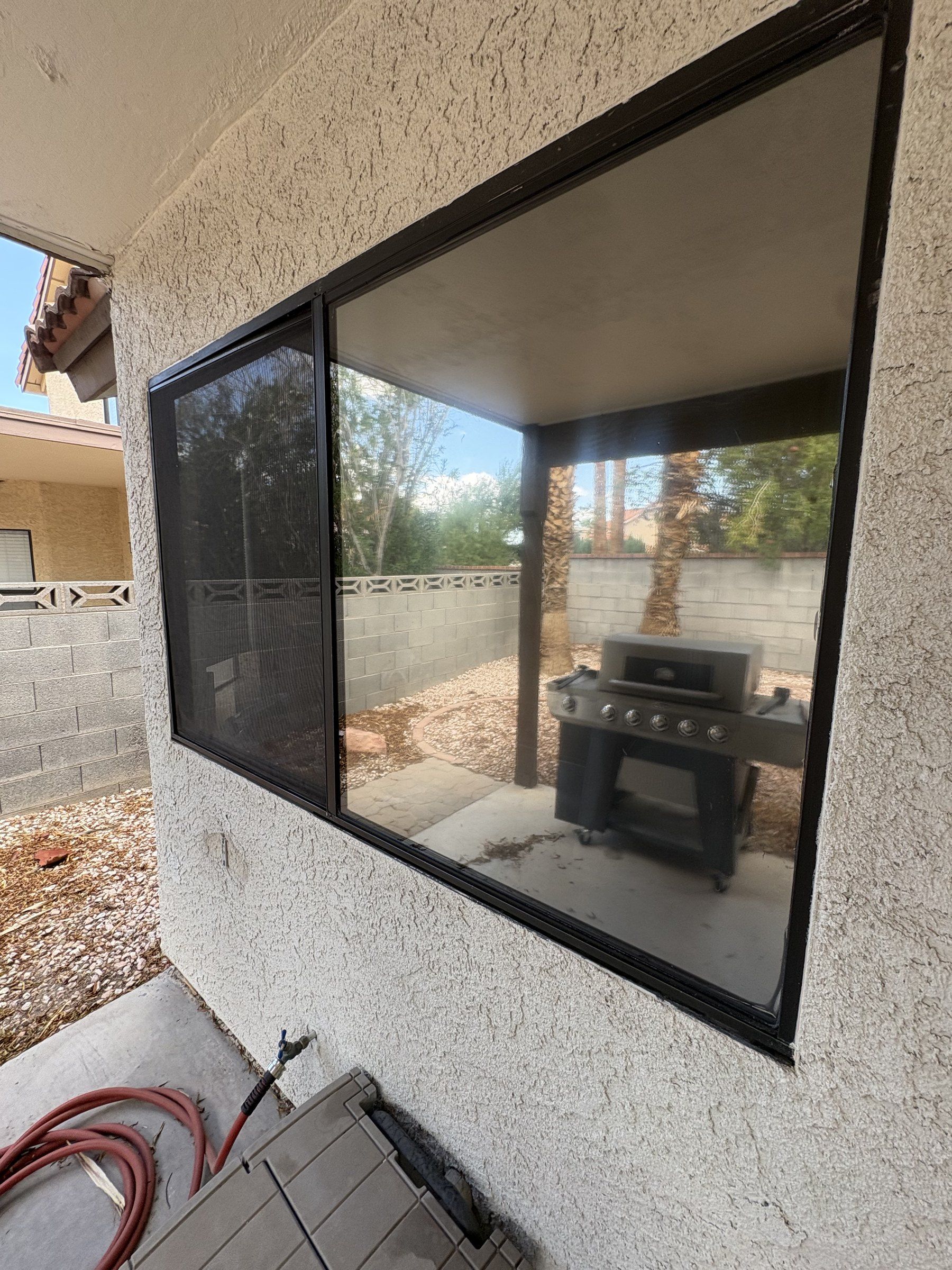 Cleaned picture window at a Las Vegas Valley home, reflecting the back yard, palm tree and block wall
